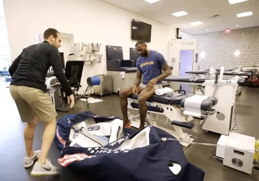 Two men in a room with a medical equipment.